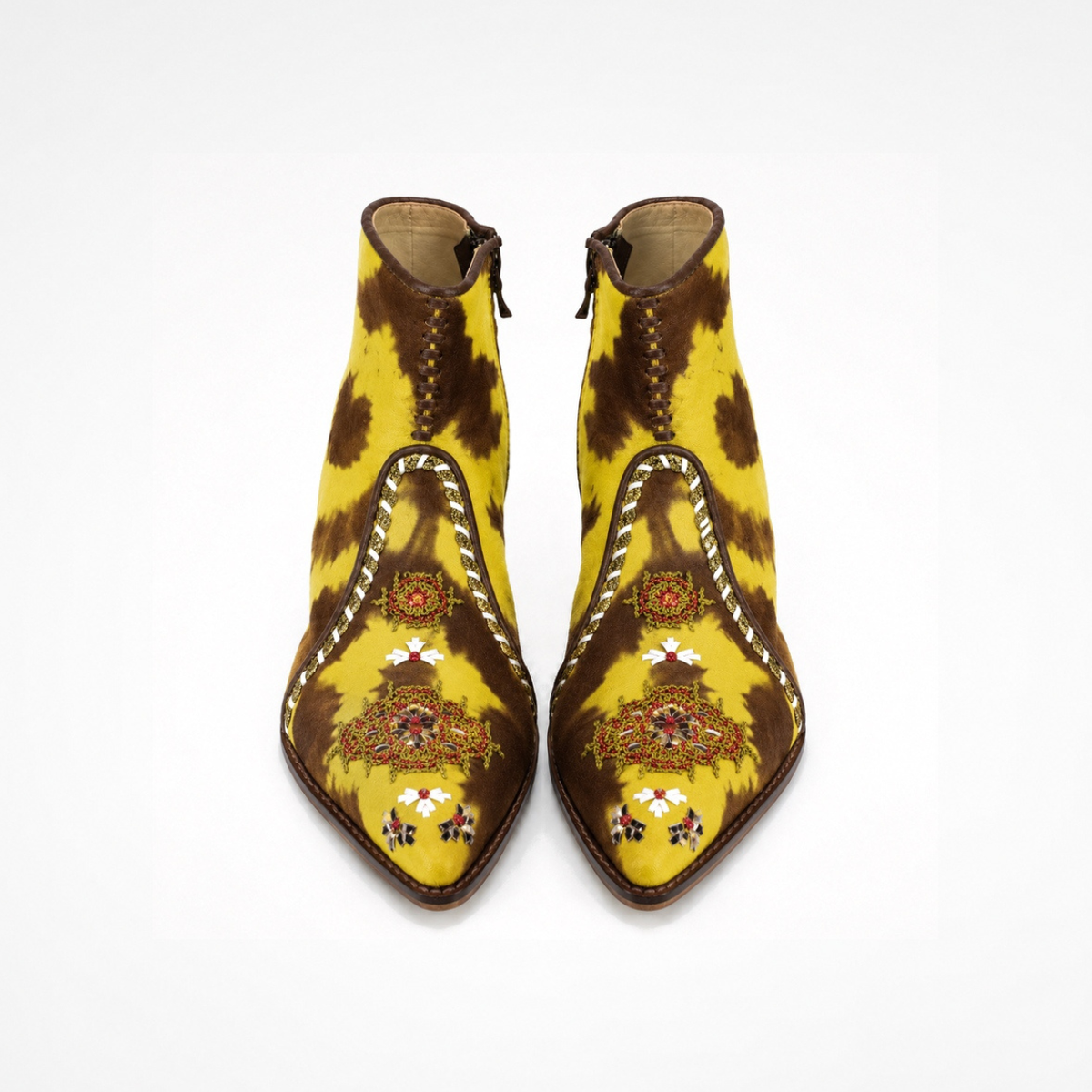 Pair of brown-and-yellow tie-dye suede NANA heeled ankle boots with embroidered front panels, front view