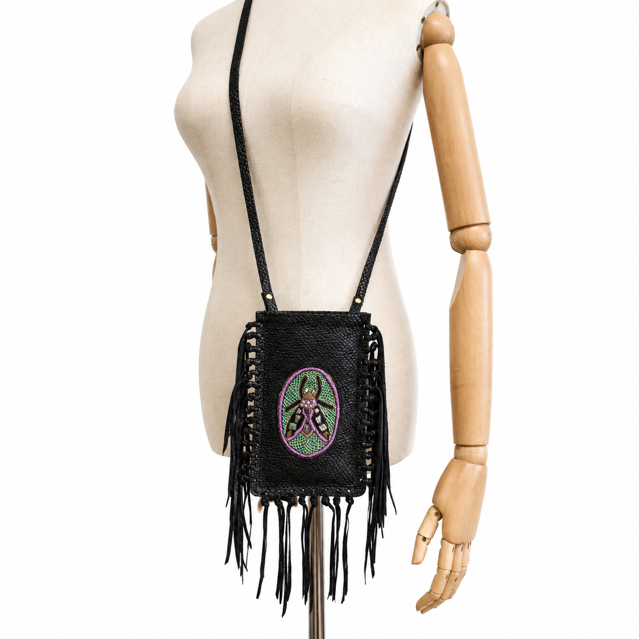 Mannequin wearing the brown leather FRINGE Phone Bag crossbody with embroidered insect motif and leather fringe