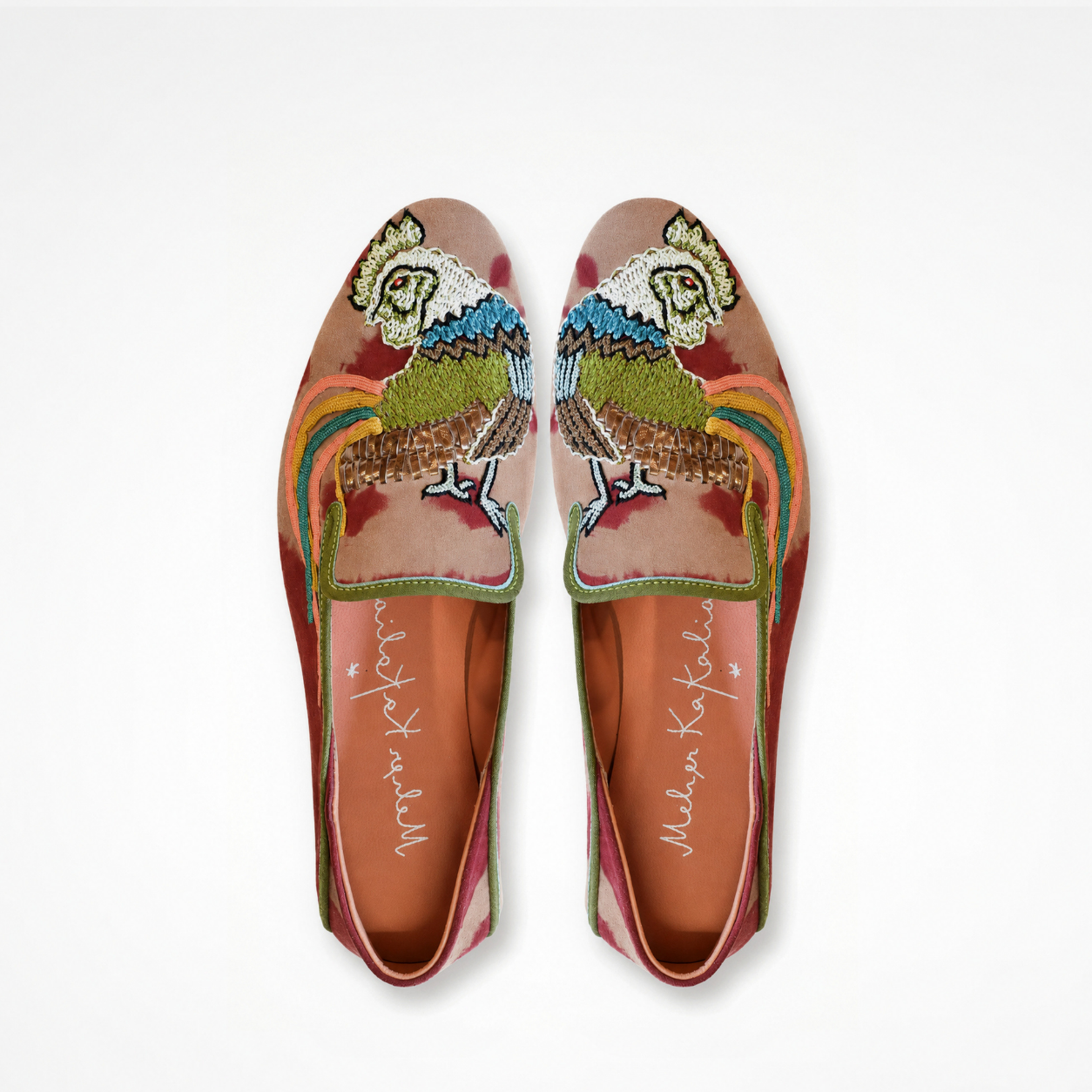 Pair of tie-dye suede moccasins showing embroidered bird motifs and contrasting green piping