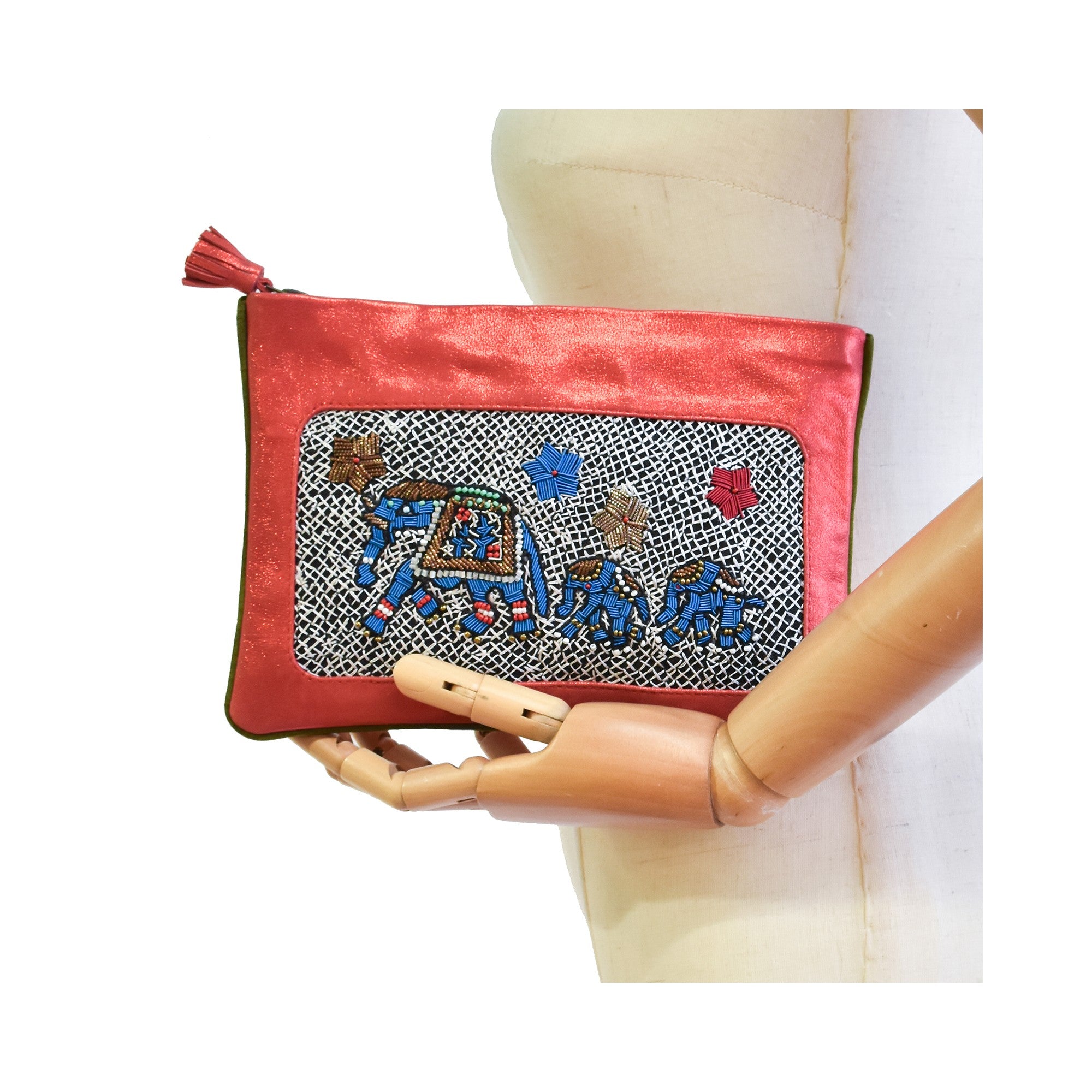Mannequin holding the limited-edition coral elephant-embroidered pochette