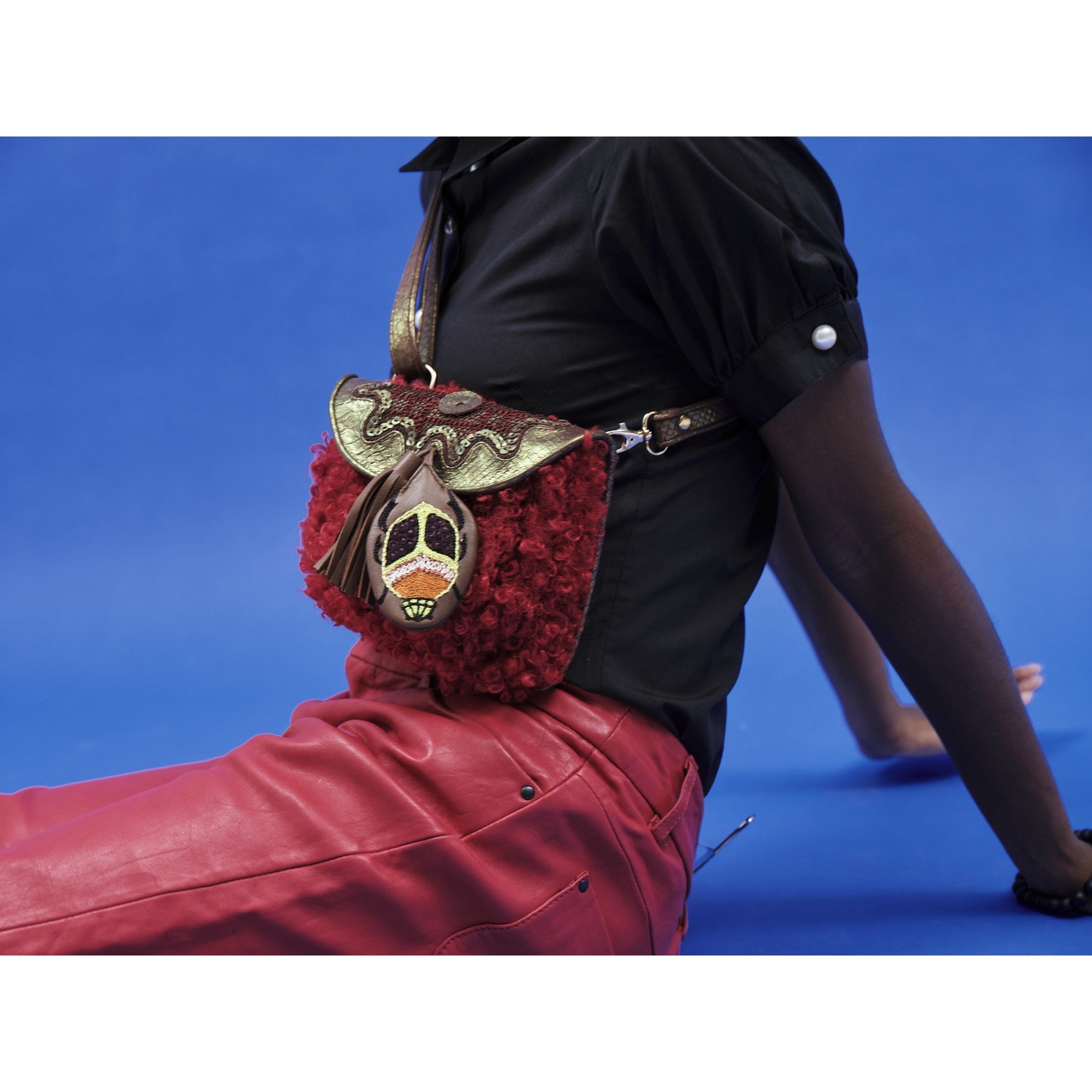 Mini accordion bag worn crossbody, pomegranate red faux shearling with embroidered leather detail
