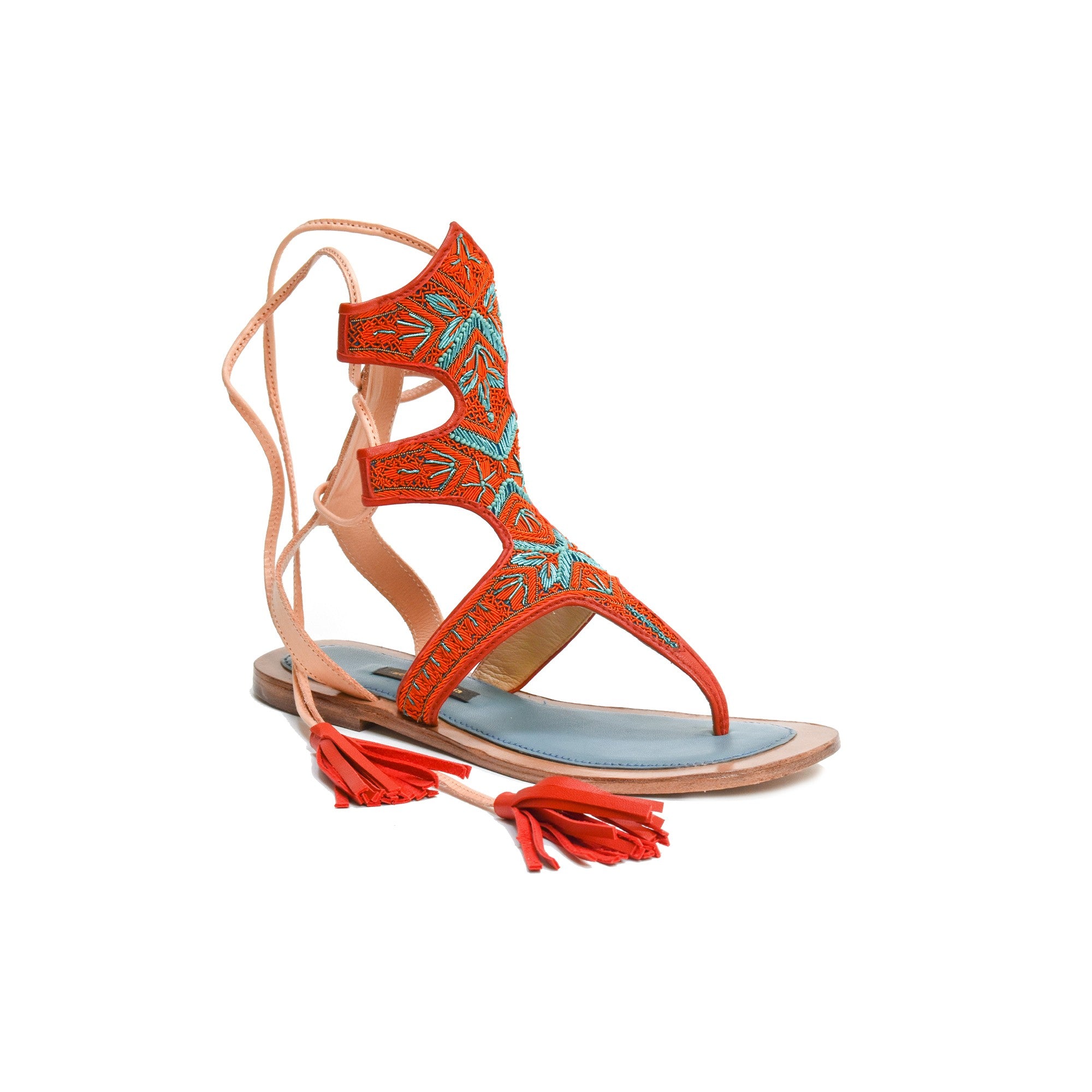 Side view of Clio Sandal in orange, a toe gladiator sandal with coil embroidery and wraparound leather ties for a secure fit.