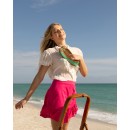 Meher KakaliaWoman on the beach holding Meher Kakalia mint green embroidered ballet flat