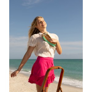 Woman on the beach holding Meher Kakalia mint green embroidered ballet flat