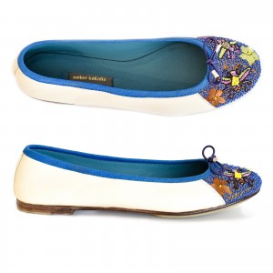 Side view of handcrafted white ballerinas with intricate blue stitching and soft leather finish.