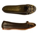 Meher KakaliaBlack ballet flats by Meher Kakalia with black and gold embroidery and black trim.