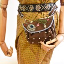Meher KakaliaJewel Accordion Bag in suede toffee worn on a mannequin as a belt bag with adjustable strap.
