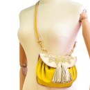 Meher KakaliaCanary yellow mini crossbody bag with polar white embroidery and pink trim.