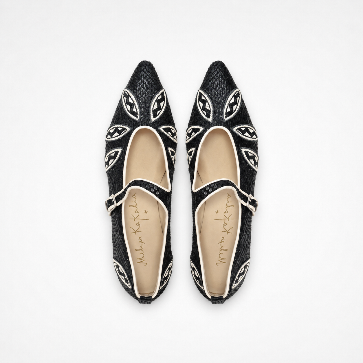 Pair of black textured leather Lullu Point Mary Jane ballet flats with white embroidered leaf motifs and buckle straps
