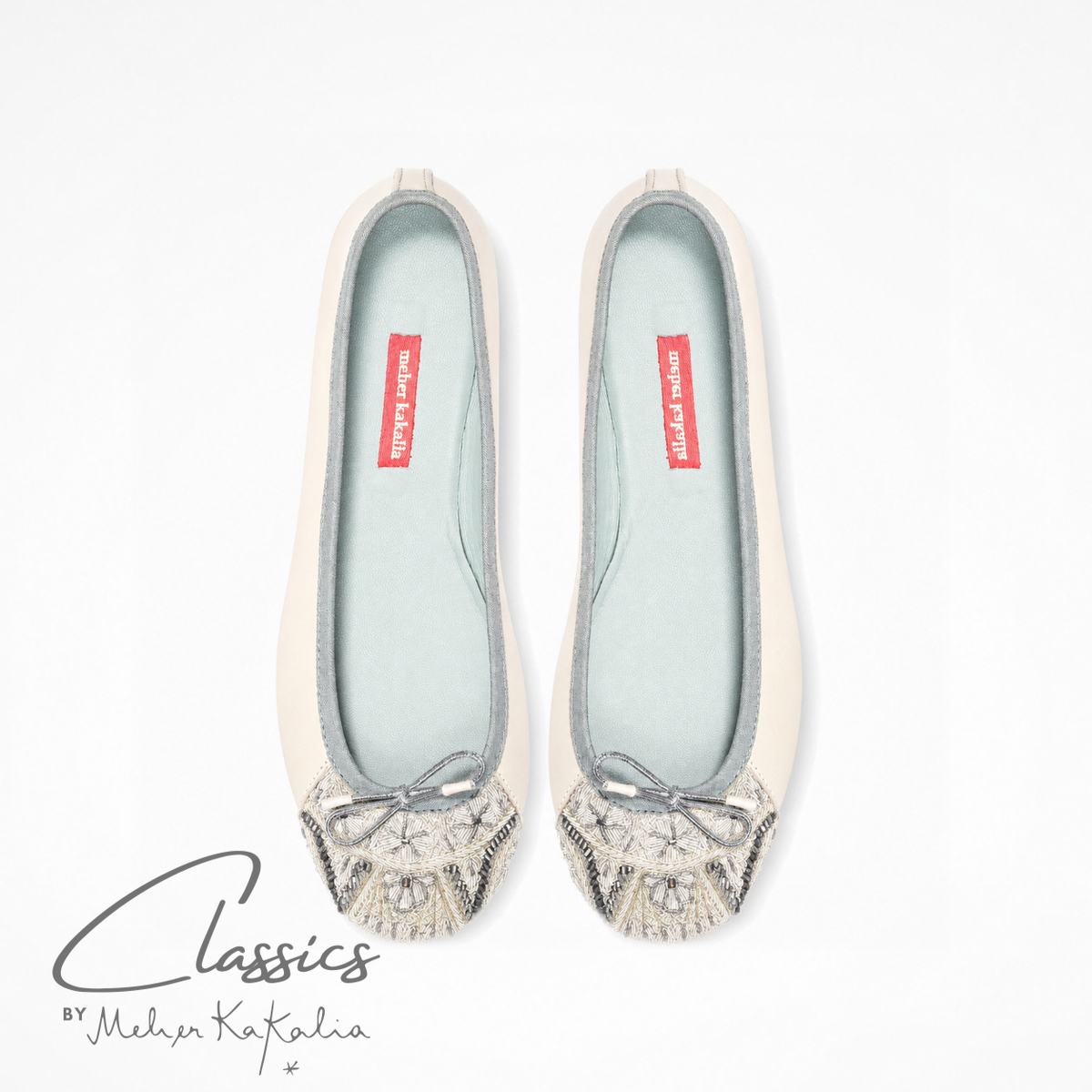 Pair of white leather BIZI ballet flats with hand-embroidered toe caps, top view