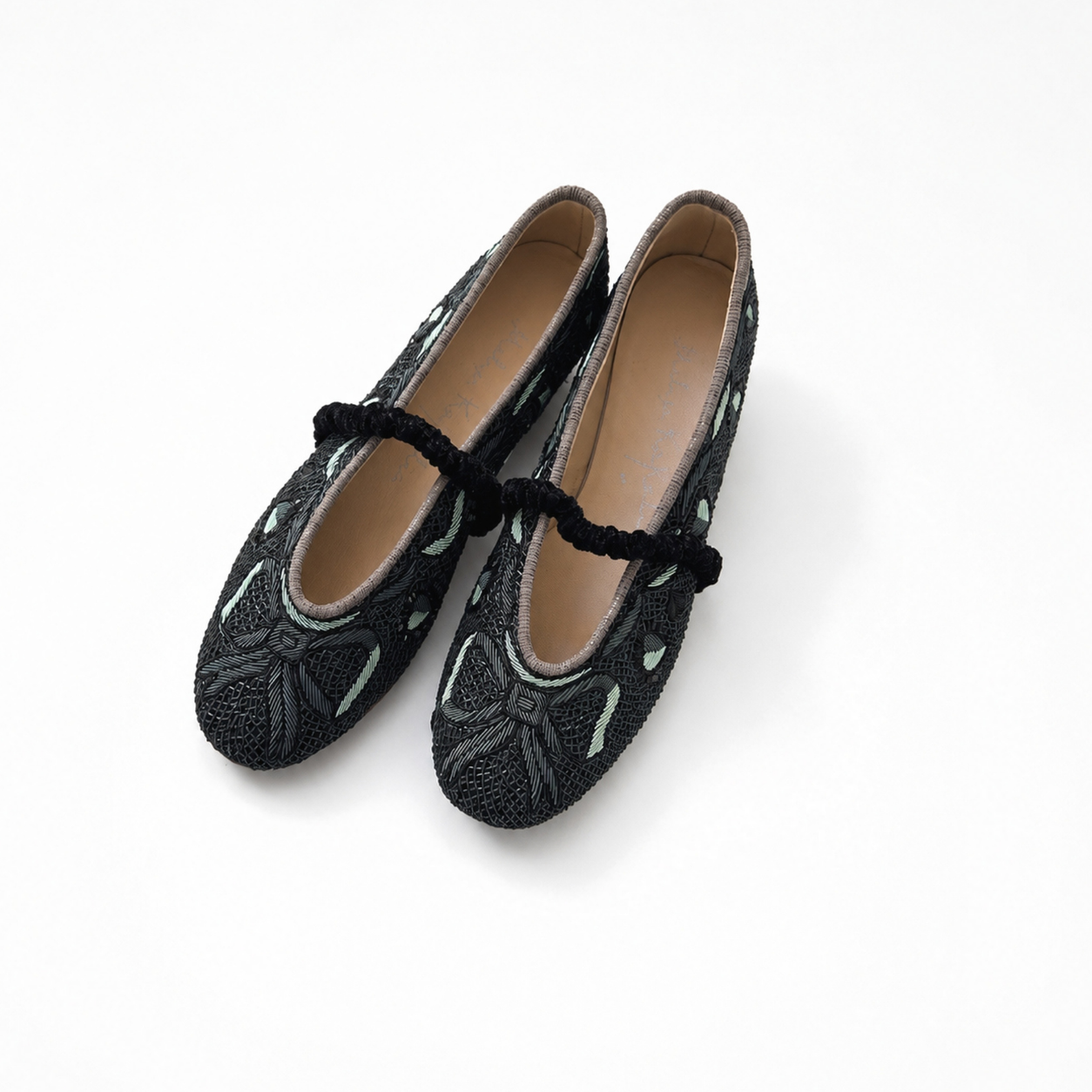 Pair of Darcey Ballet flats in black and teal showing embroidered motifs and ruched straps
