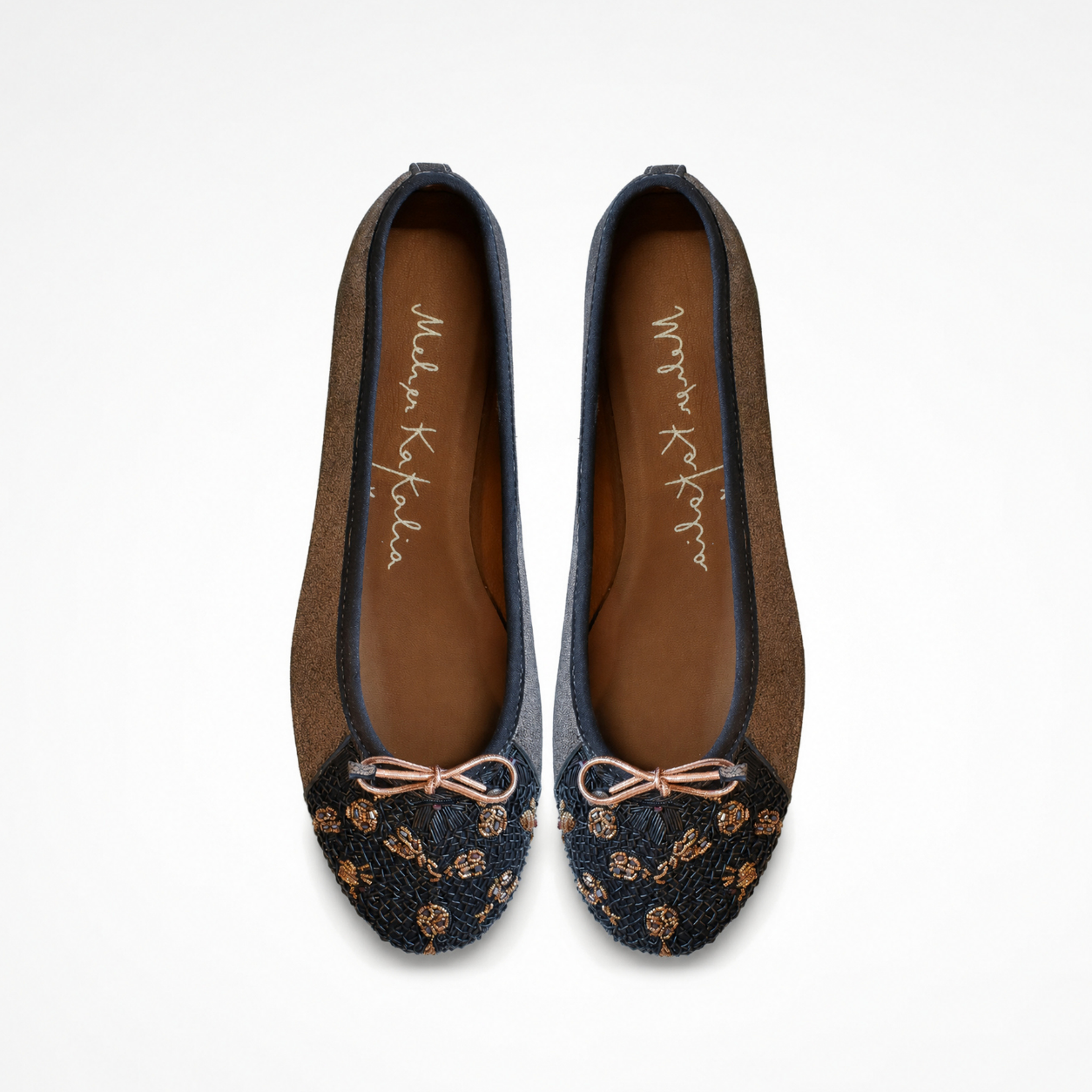 Pair of Eden Ballet flats in beige and black leather, top view showing embroidered toe panels and bows