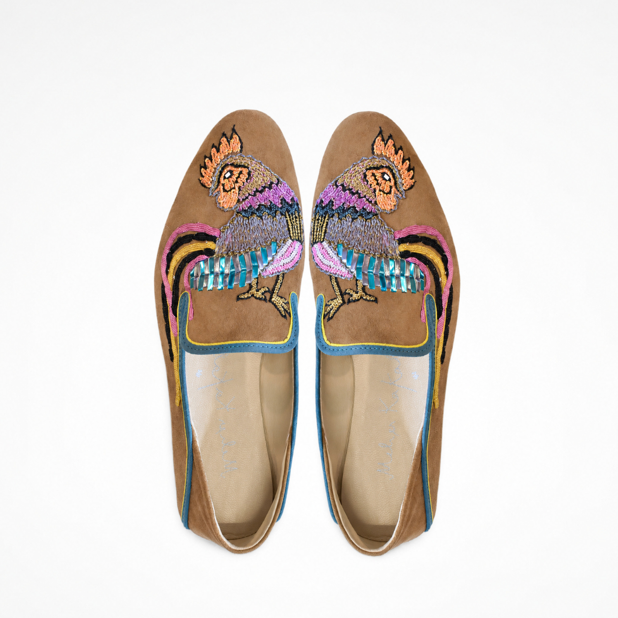 Pair of spice suede moccasins showing embroidered bird motifs and contrasting blue piping