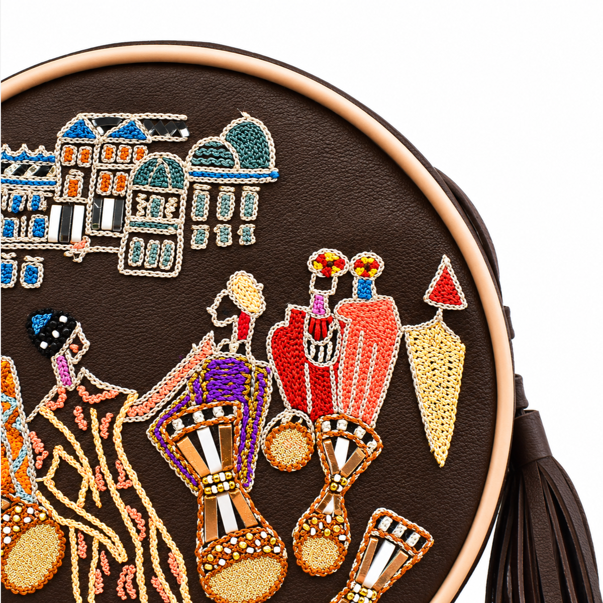 Close-up of brown Marrakesh Round Bag showing fine-coil embroidered buildings, figures and beaded drums