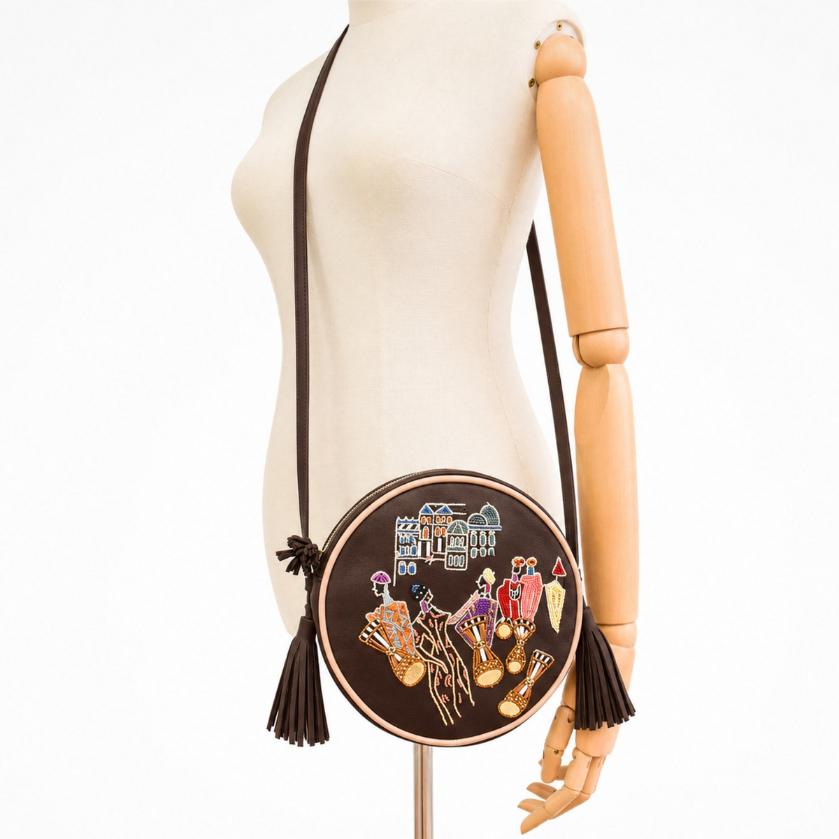 Mannequin wearing the brown nubuck Marrakesh Round Bag as a crossbody bag with long leather strap