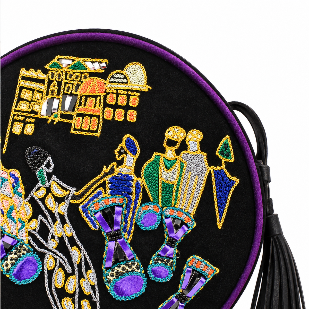 Close-up of black suede Marrakesh Round Bag showing embroidered domed buildings, figures and purple satin drums