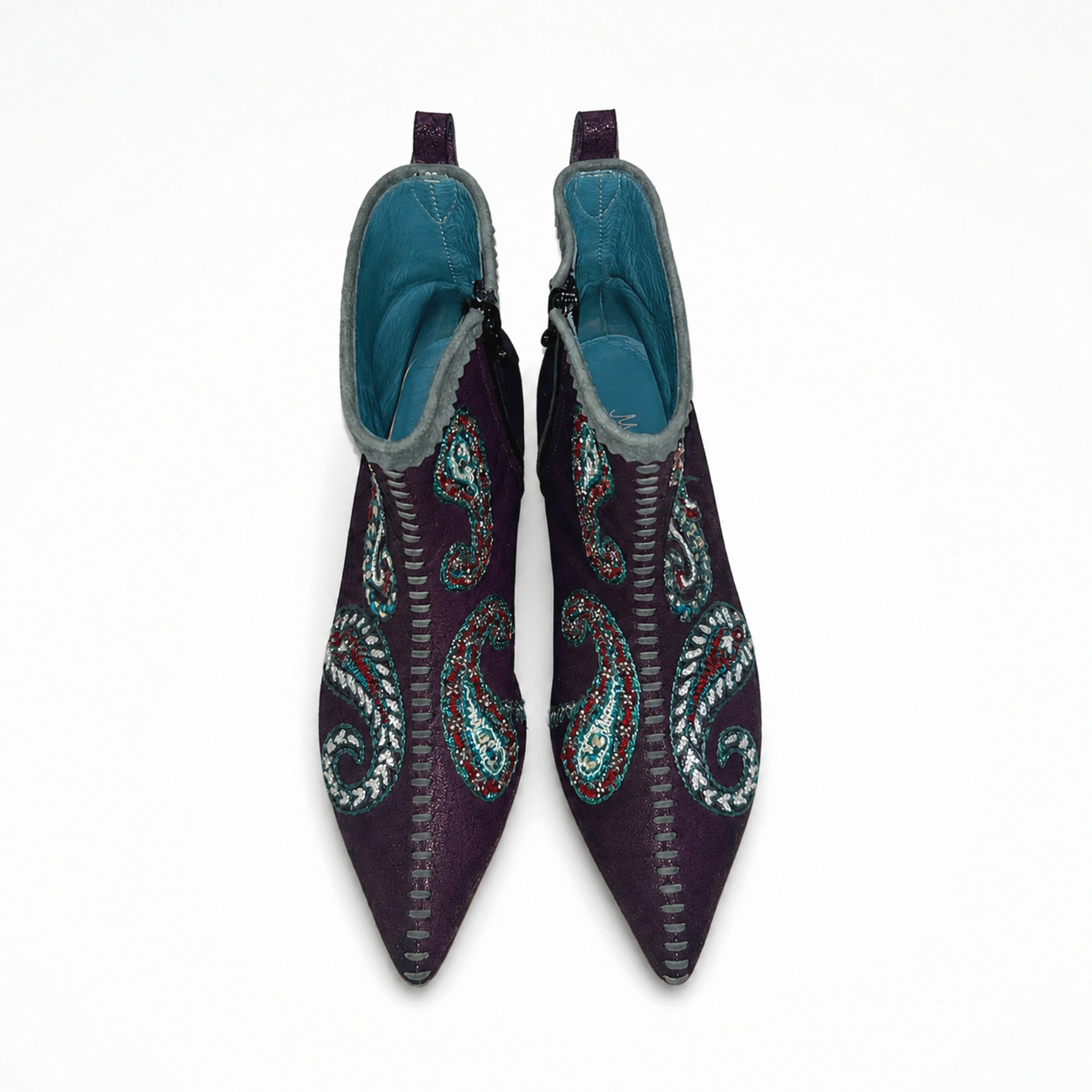 Pair of pointed burgundy ankle boots showing paisley embroidery and front whipstitching