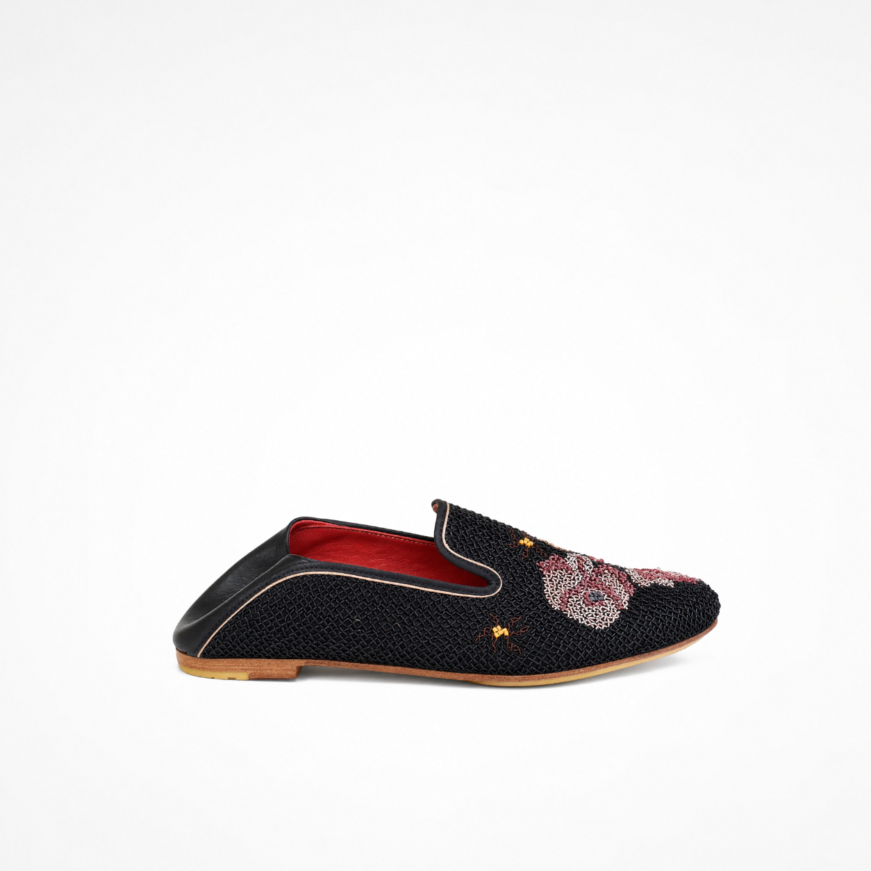 Side view of a black embroidered Queen Nora Loafer with a smooth leather heel panel and pale pink piping