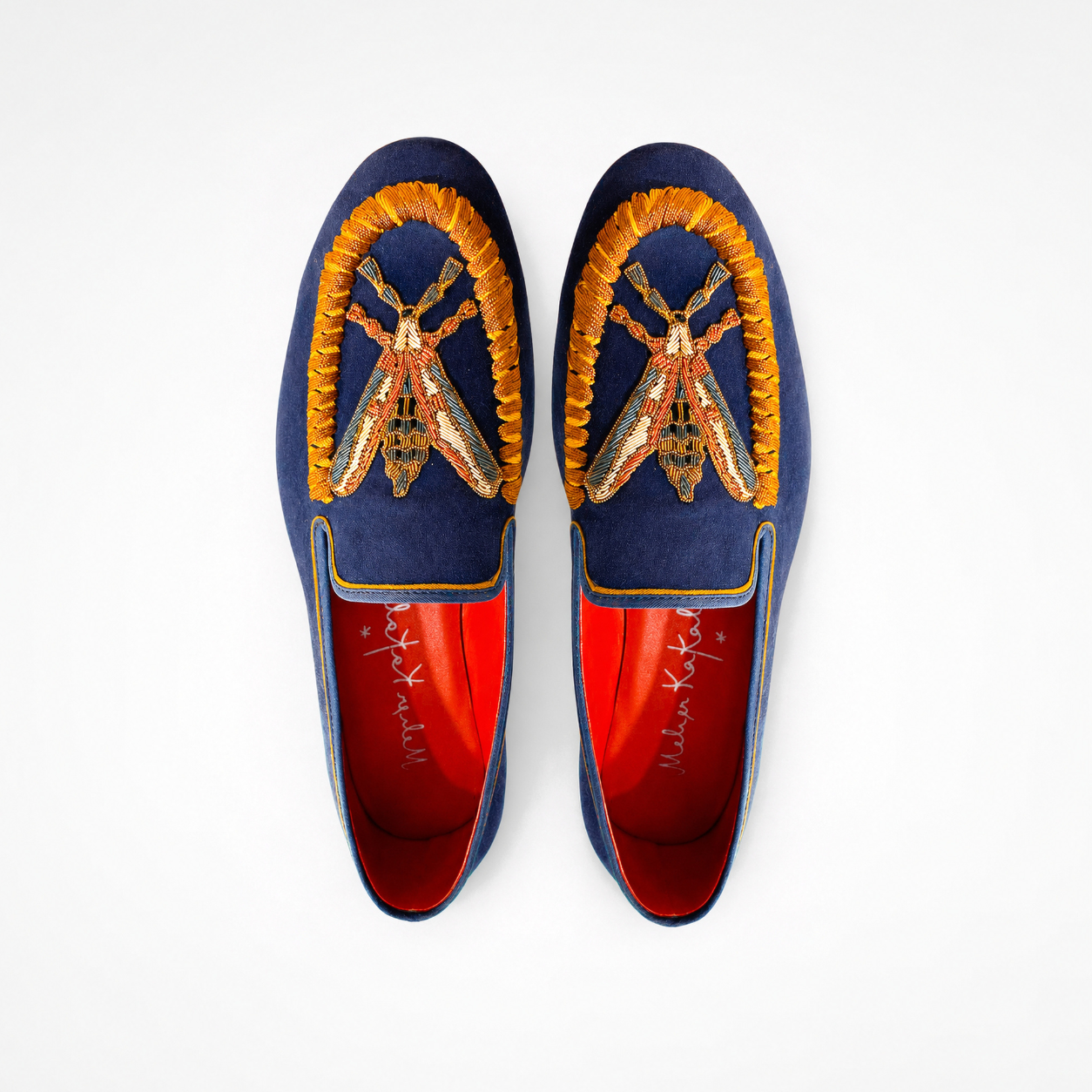 Pair of navy suede loafers showing gold and orange insect embroidery and rounded toes