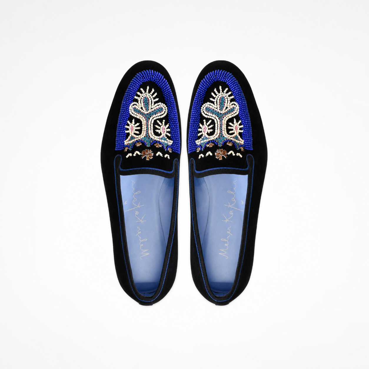 Pair of black suede loafers showing blue and white beadwork and embroidered fronts