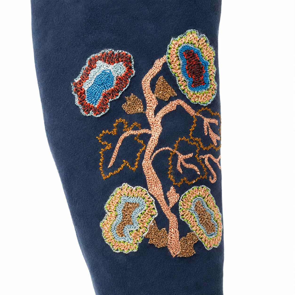 Close-up of botanical hand embroidery on the navy suede shaft of the TONYA Boot