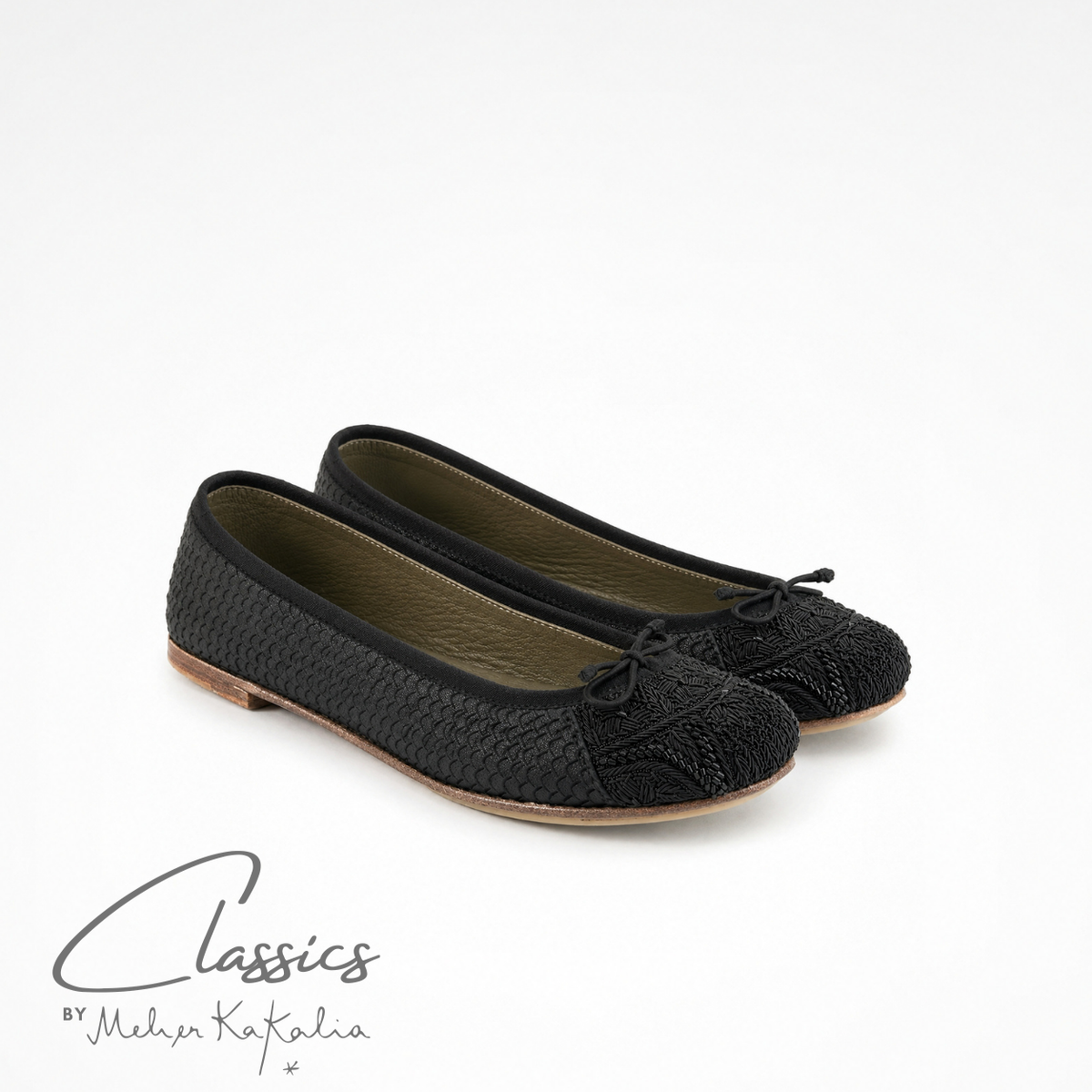 Pair of black leather BIZI ballet flats with hand-embroidered toe caps, angled view